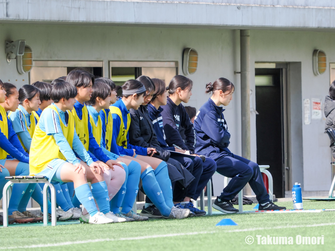 前キャプテン・新井萌禾がコーチとしてベンチ入り。厳しい視線で戦況を見守る。