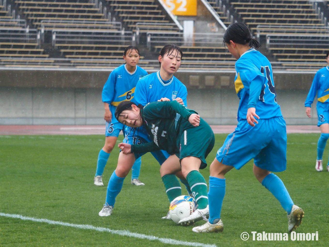 湘南学院のフォワードとサイドハーフのチェックを受けながらもボールを前に運ぼうとする岡田夏実。